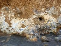 Öffnung im bunten Hang über heißem Abflußgraben bei Seltún